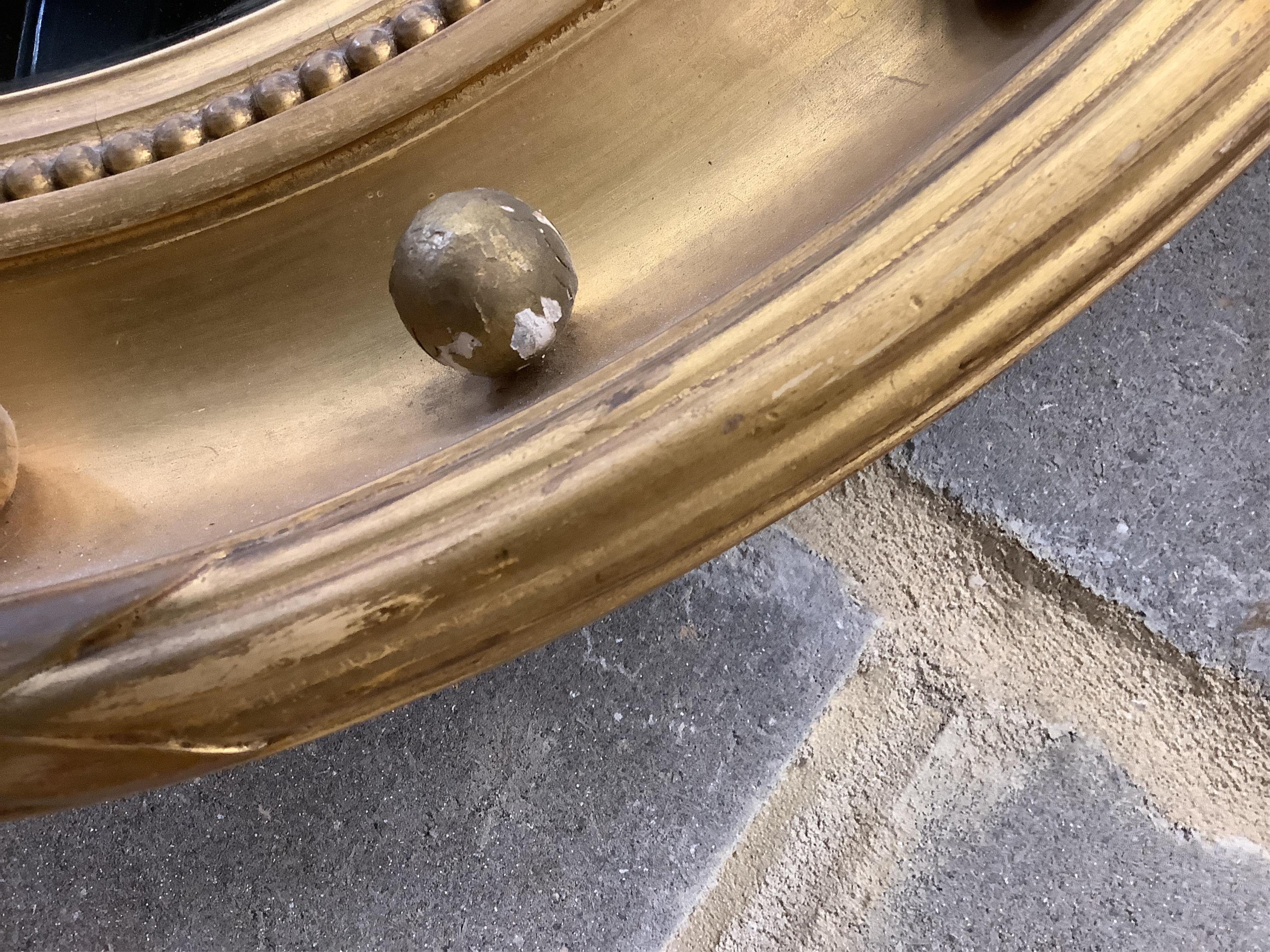 Two Regency style circular giltwood and composition convex wall mirrors, larger diameter 58cm. Condition - fair